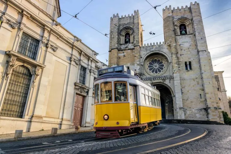 black and orange Tram 28 on the streets of Lisbon