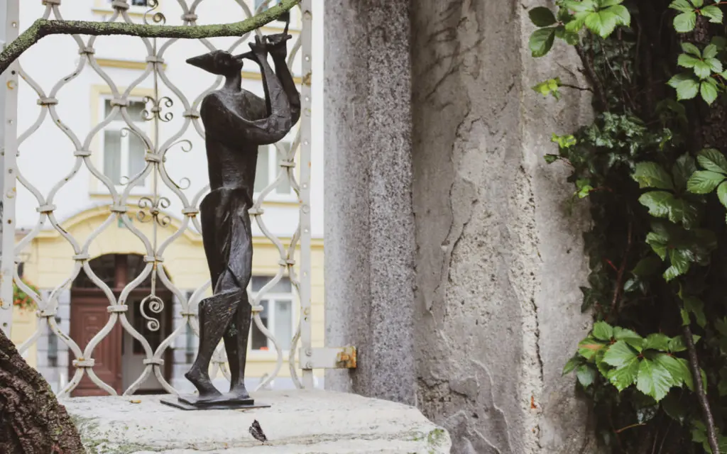 a statue of a man playing a flute