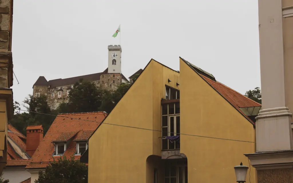 a building with a tower on top of it and Ljubljana Castle in the distance