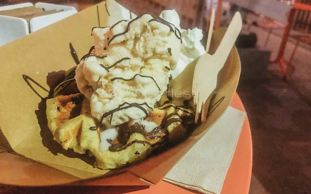 dessert topped with gelato in a food tray on a table