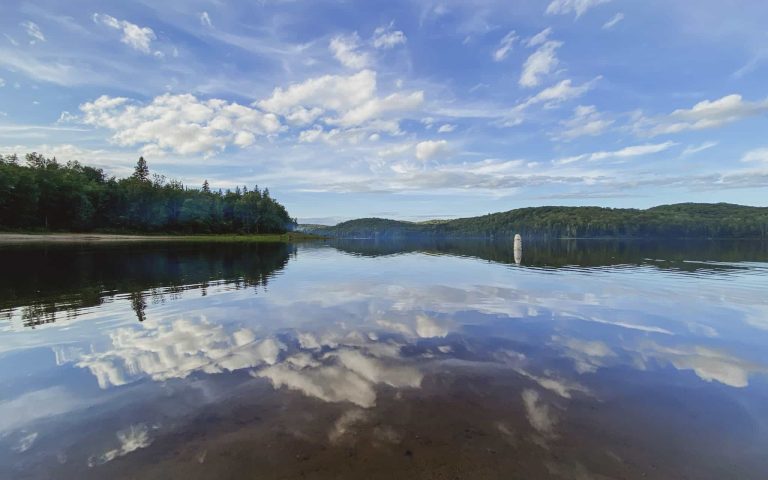 a lake in Hunstville with trees and clouds in the sky