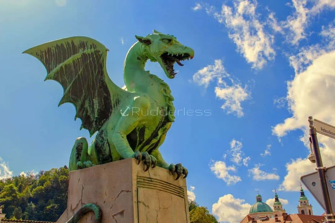 a green dragon statue on a stone pillar